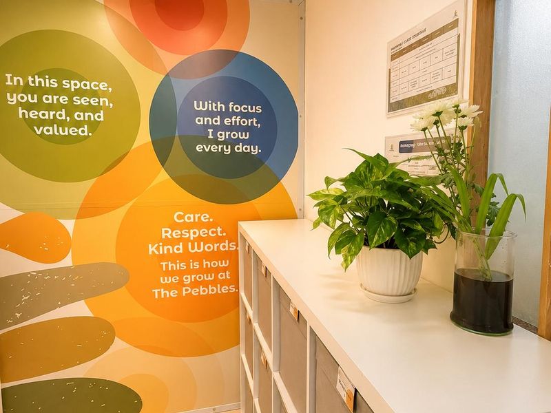The Pebbles values wall — 'In this space you are seen, heard and valued. With focus and effort, I grow every day. Care. Respect. Kind Words.'