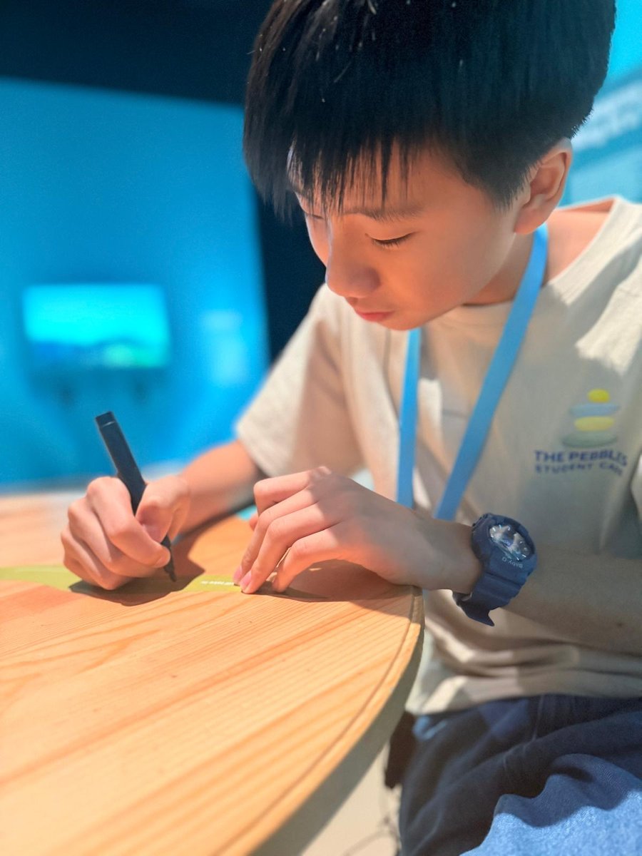 A Pebbles student writing in the Maker Monday library